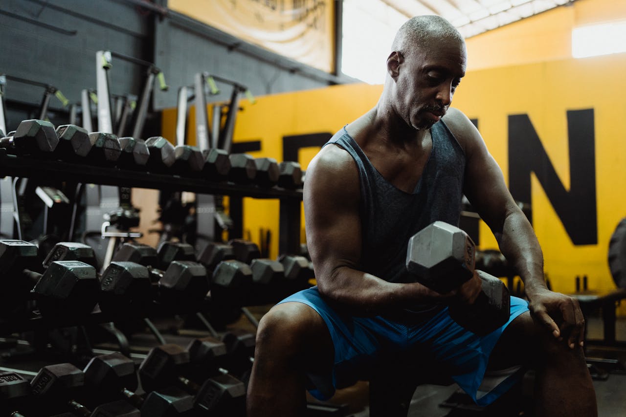 hero-img-01 Focused man lifting weights in a gym, building strength and muscle.